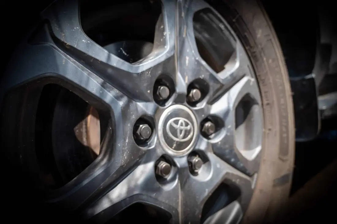 Close-up of a dark Toyota alloy wheel and tyre, with dust on the spokes